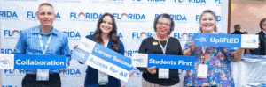 2024 Talent Strong Florida - Access for All attendees pose with message signs in front of a logo background at the Hilton Orlando annual summit